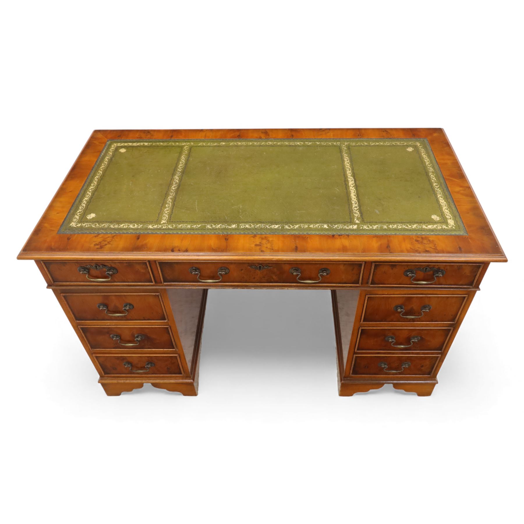 Late 20th century yew wood nine drawer writing desk, rectangular top inset with gilt-tooled green leather, above an arrangement of nine drawers with brass swan-neck handles, raised on bracket feet