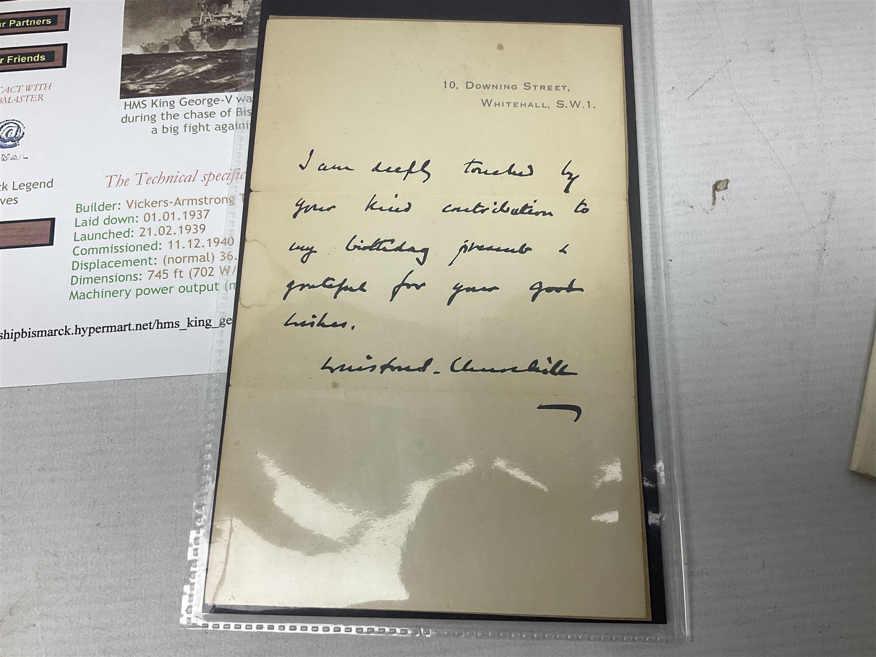 Disbound WW2 album relating to the battleship HMS King George VI containing over fifty various size loose photographs of the ship in action, guns firing, crew members, aircraft, two of George VI on board, three of Winston Churchill on board, official 1942 Christmas messages including Franklin Roosevelt etc; together with unrelated printed letter on 10 Downing Street notepaper from Winston Churchill; and Order of Service for Churchill's funeral at St. Paul's Cathedral 30th January 1965