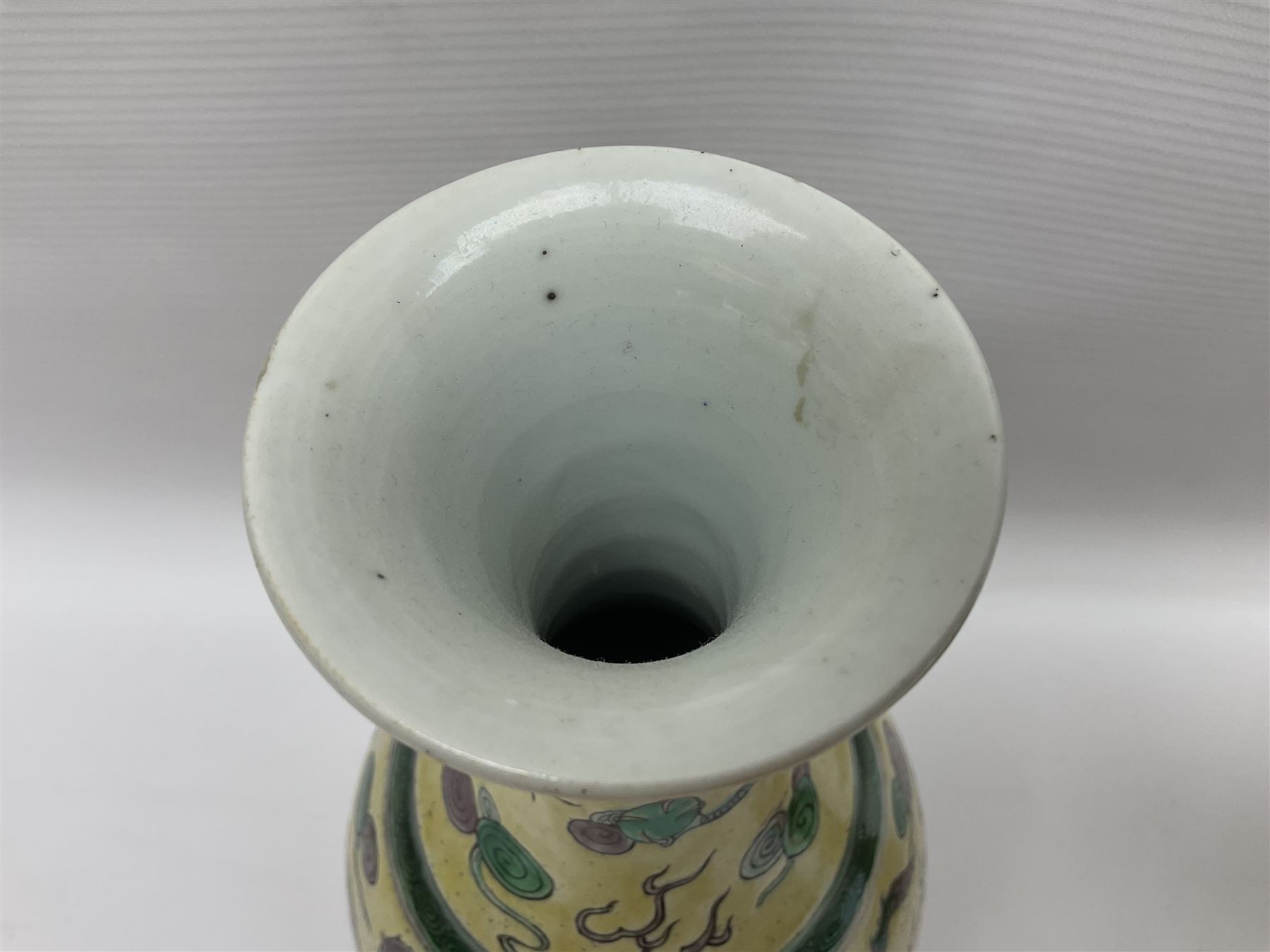 20th century Chinese Famille Verte vase, of slender ovoid form with tapering neck and flared rim, decorated with green and grey enamel with dragons chasing flaming pearls amongst auspicious clouds upon a yellow ground, H30cm