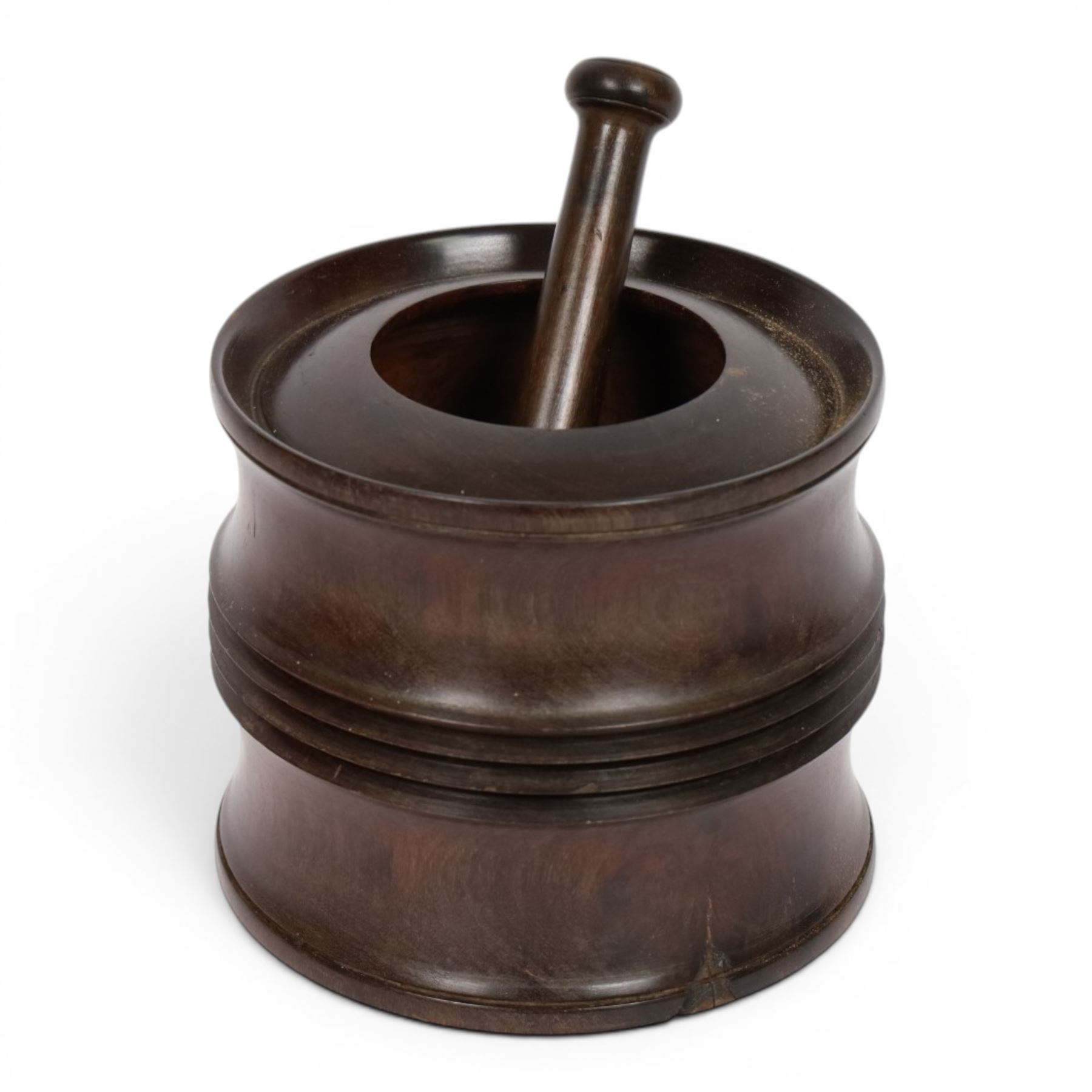 18th century lignum vitae captive mortar and pestle, the mortar of turned waisted form with central reeded girdle, and captive opening with rolled rim, H12.5cm D14cm, and pestle L17.5cm