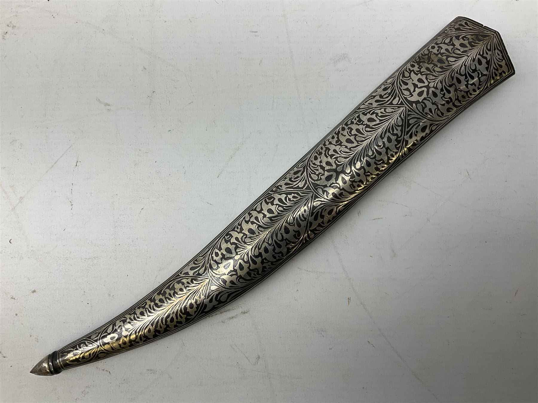 Indian Khanjar dagger with 28cm curving damascus steel blade inlaid with silver floral emblem, white metal and niello style grip in the form of a bird's head with pronounced beak and matching scabbard L44cm overall