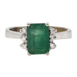 White gold emerald ring set with three round brilliant cut diamonds either side