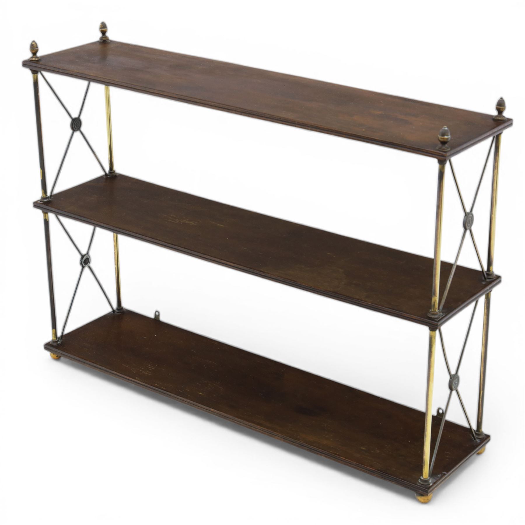 Regency brass and mahogany wall shelves circa 1820, the three shelves contained within a brass cross brace with brass finials, with wall fixings 
