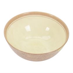 1930s Clarice Cliff Bizarre for Newport Pottery bowl, decorated in the Canterbury Bells pattern, the exterior painted with stylised flowers in blue, yellow and orange amongst foliage upon a brown and yellow Cafe au Lait stippled ground, with black printed mark beneath, D18cm
