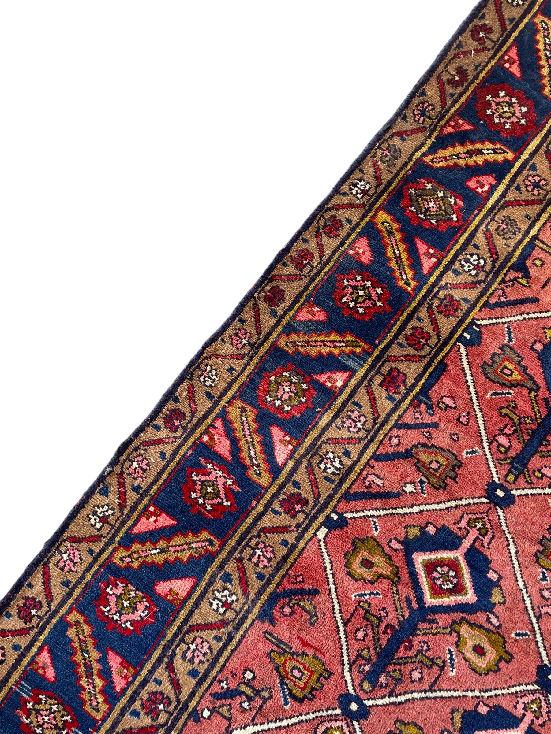 Persian Ardakan crimson ground rug, the field divided by lattice and decorated with stylised tree of life motifs, the border decorated with geometric flower heads, within guard stripes 