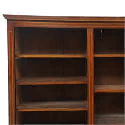 Quality Edwardian inlaid mahogany triple-column open bookcase, projecting cornice over a satinwood banded frieze, fitted with fourteen adjustable shelves with strung facias, the shaped apron on bracket feet