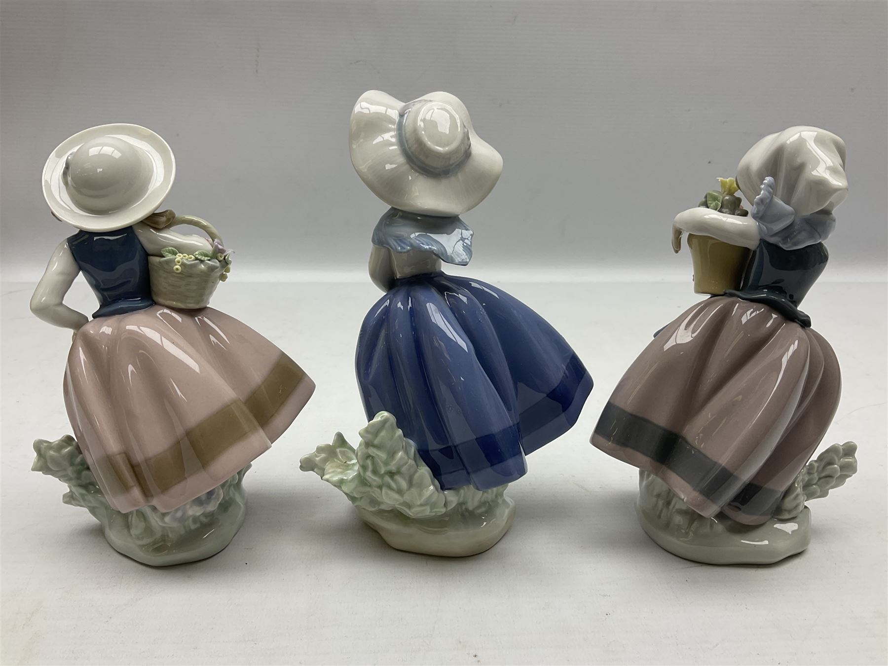 Three Lladro Flower Girls figures, comprising Sweet Scent no 5221, Pretty Pickings no 5222 and Spring is Here no 5223, largest example H18cm 