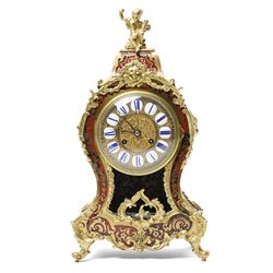 Rollin à Paris - 19th century French Louis XV style ormolu-mounted red tortoiseshell and brass Boulle-work mantel clock, surmounted by a seated musical putto above a waisted case applied with mask, rocaille, foliate and dolphin mounts, the gilt dial with white enamel Roman numeral cartouches, twin-train movement striking on a bell, signed and numbered 480, on four scrolling foliate feet