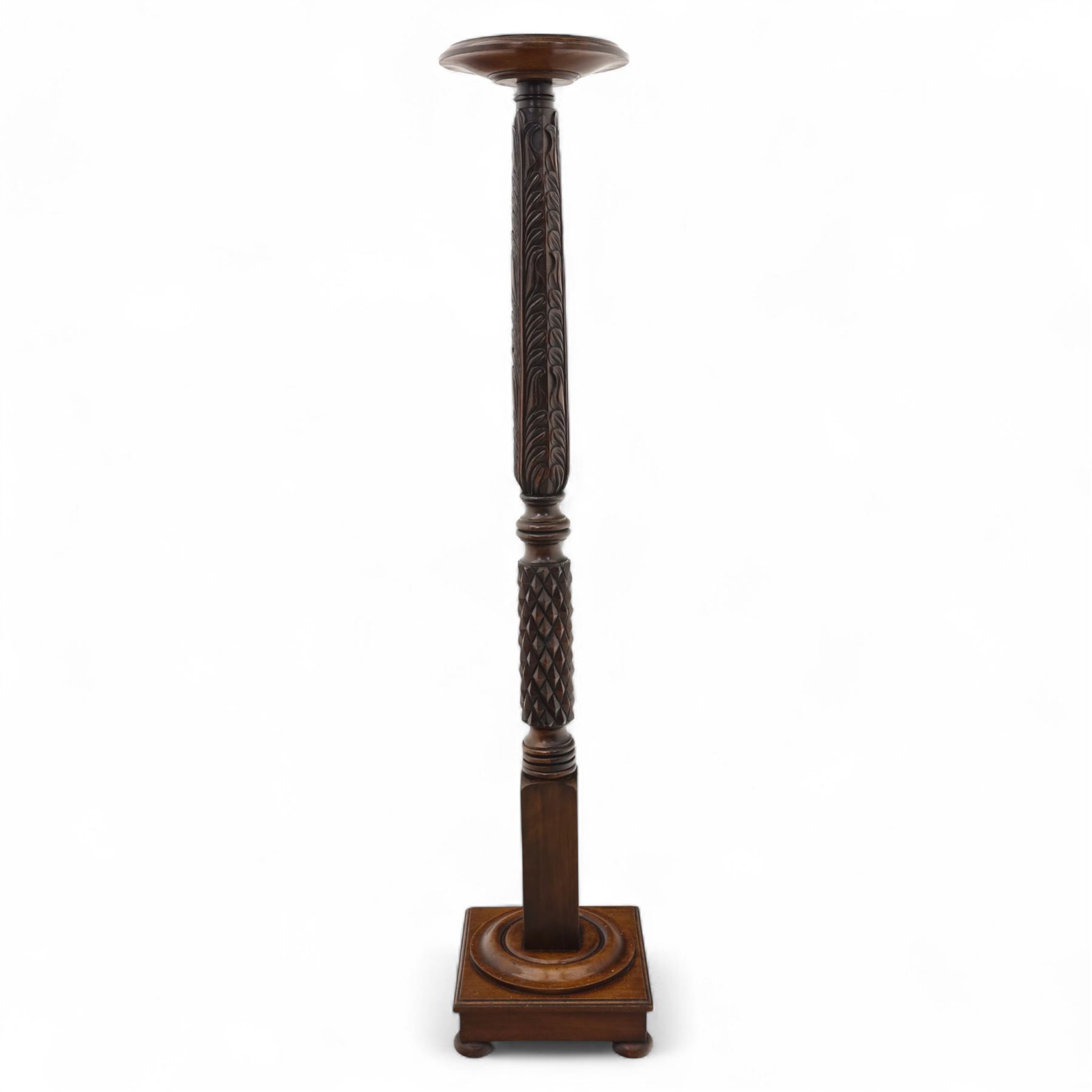 Late 20th century carved mahogany torchère stand, dished top above heavily carved column, with turned elements on moulded square base upon bun feet