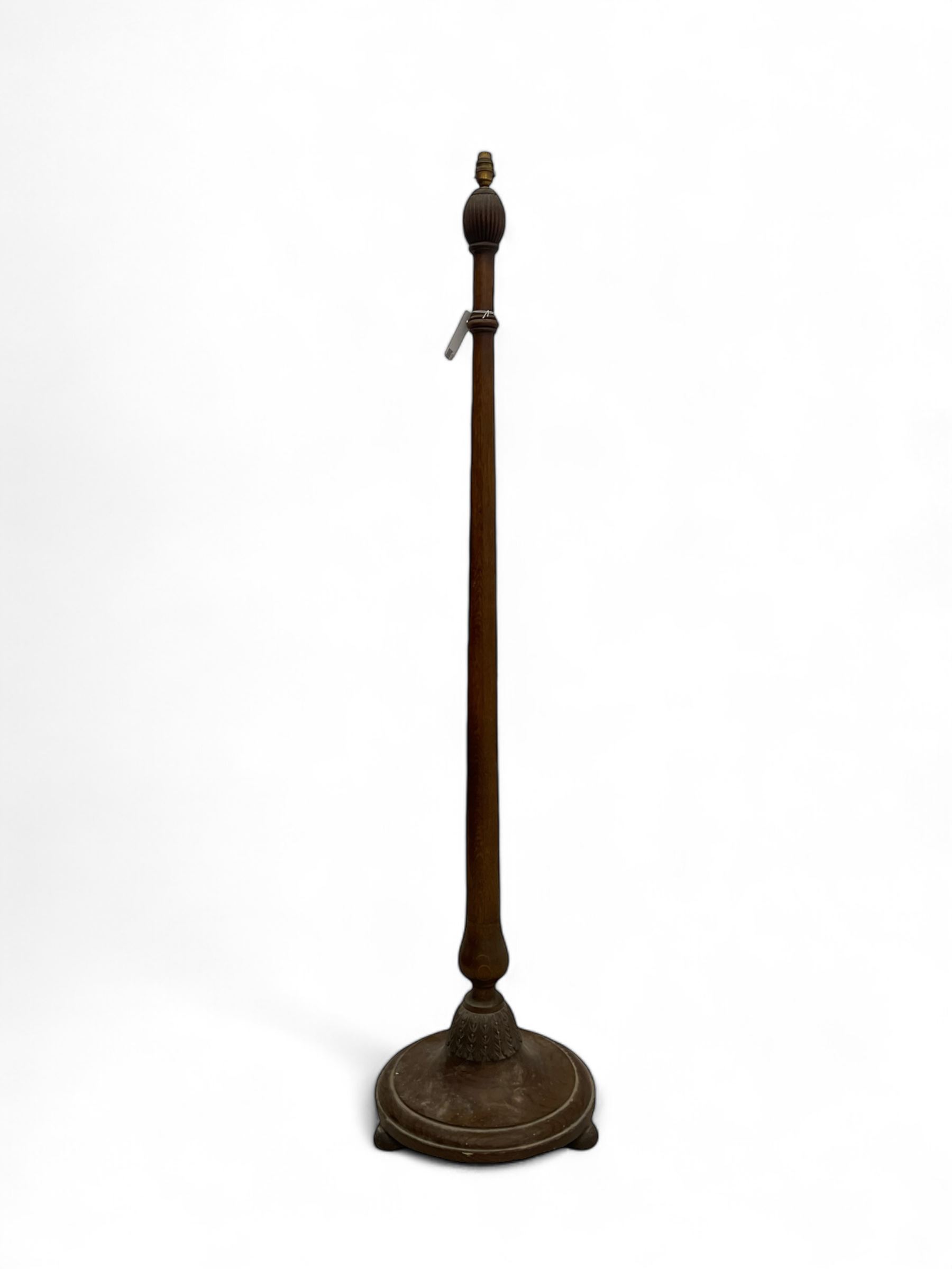 Early 20th century oak standard lamp base, of baluster form with fluted acorn finial and carved foliate decoration to the base, raised on circular plinth with bun feet