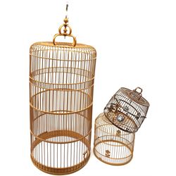 A large extendable Chinese birdcage, together with two smaller examples, one with ceramic water bowls. (3). 