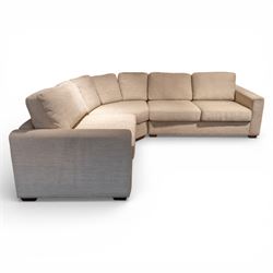 Contemporary modular corner sofa, upholstered in neutral fabric, with curved back fitted with loose cushions and wide seat pads, padded scroll arms and block feet, designed as three detachable sections