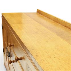 Mouseman - large adzed light oak sideboard, the rectangular top with raised galleried back, fitted with three central drawers flanked by panelled cupboards enclosing shelves, with wrought iron fittings, raised on octagonal feet, with signature carved mouse, by the workshop of Robert Thompson, Kilburn