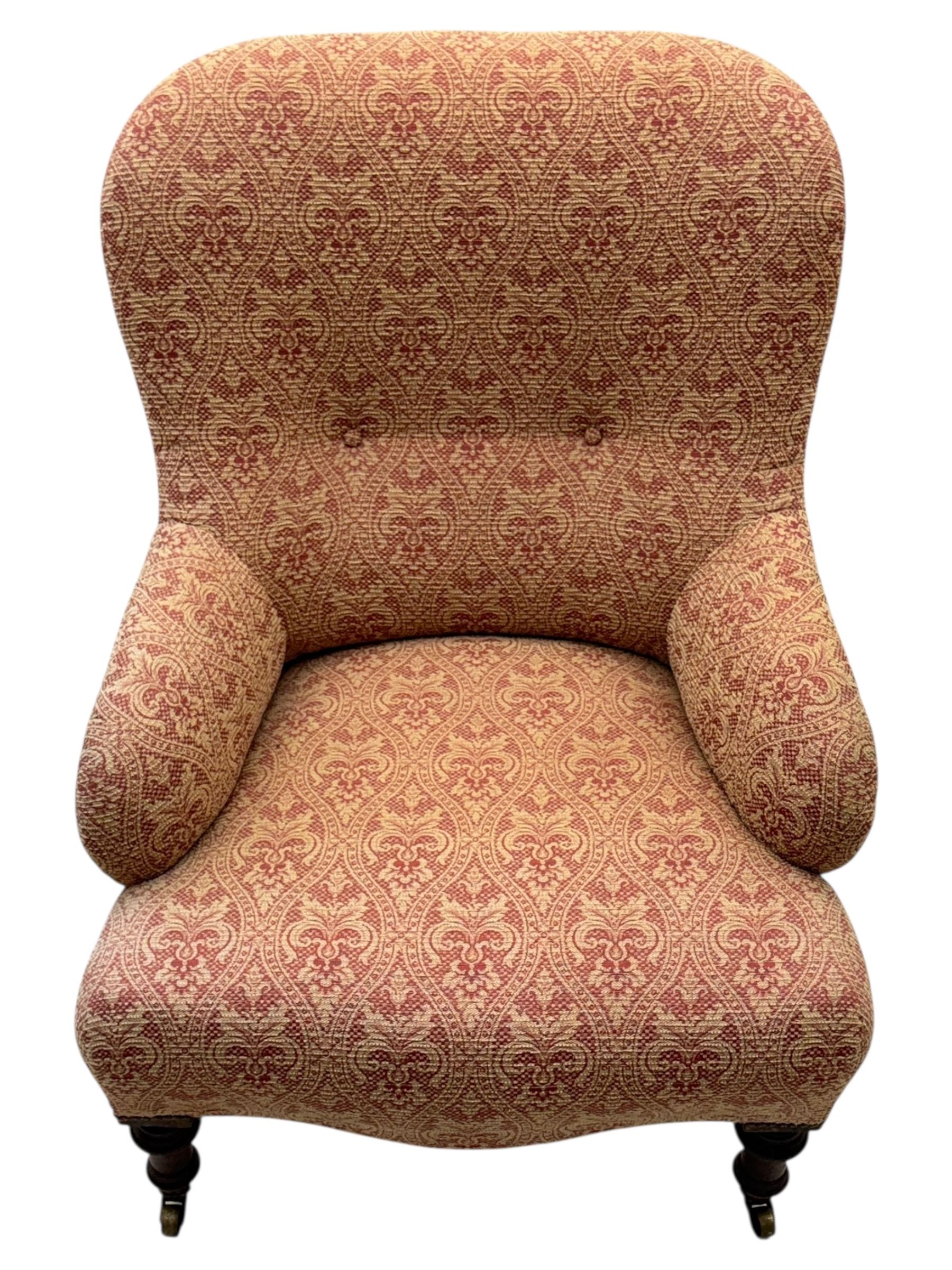 Late Victorian upholstered armchair, with high camel back and deep seat, padded arms and backrest in crimson and cream damask-style fabric, raised on turned ebonised front supports with ceramic castors (H88cm, W65cm, D 60m); and an Edwardian bedroom chair with button upholstered rail back (H72cm, D64cm, W53cm) (2)