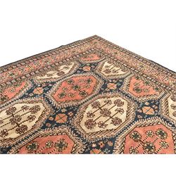 Persian design indigo ground carpet, the field decorated with extended lozenge panels with stylised floral designs, guarded border with repeating plant motifs and rinceaux 
