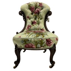 Victorian mahogany framed nursing chair, the waisted back with pierced and scroll carved decoration, upholstered in rose patterned fabric, cabriole supports