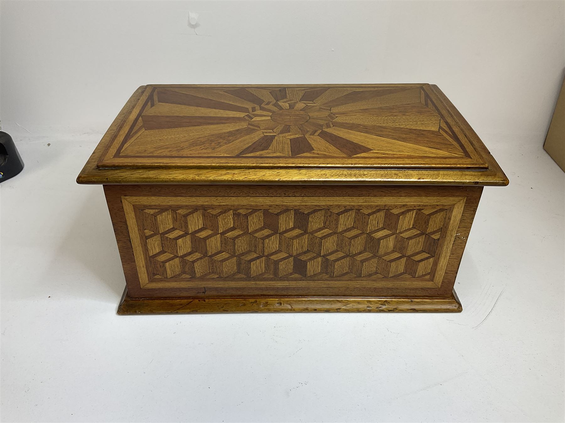 19th Century mahogany and parquetry box of rectangular form, geometric cube design, with a stylised sun detail to the hinged cover, opening to reveal three compartments, L33cm D21cm H16cm
