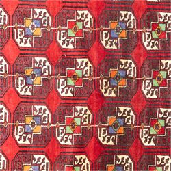 Tekke Bohara hand-knotted rug, madder red field decorated with an all-over design of repeating octagonal guls and latch-hook motifs within multiple geometric borders and cotton fringe ends 