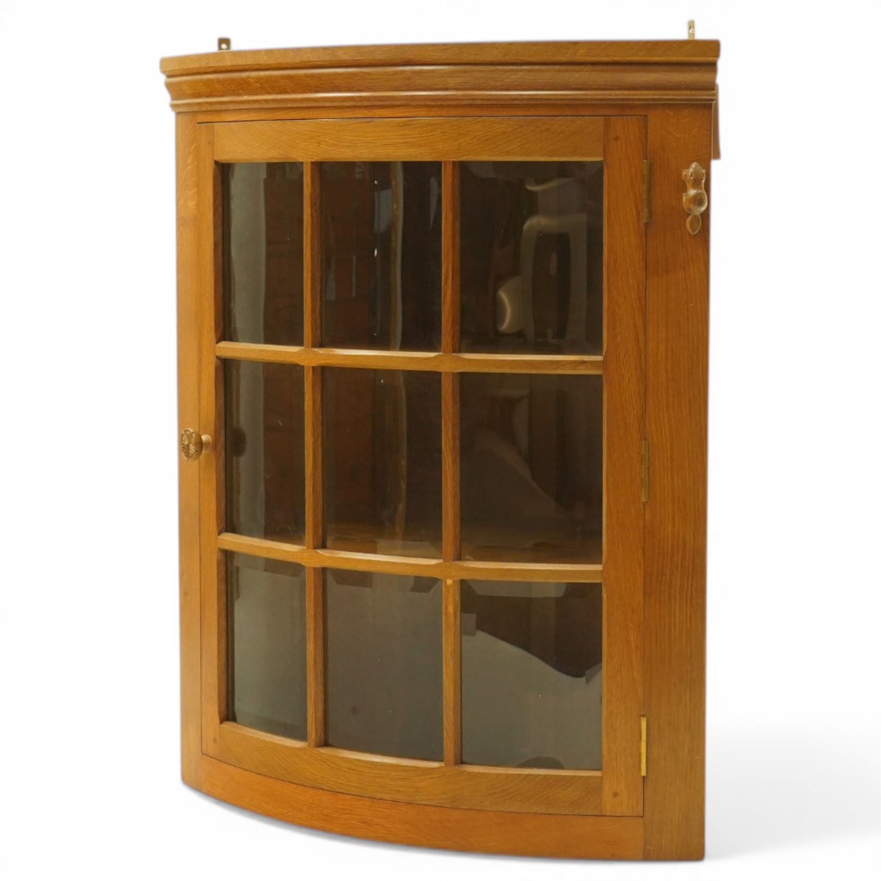Beaverman - oak hanging corner cabinet, astragal glazed door with a Yorkshire Rose door pull, revealing two fixed shelves, brass mounts for hanging, with carved beaver signature, by Colin Almack of Sutton near Thirsk