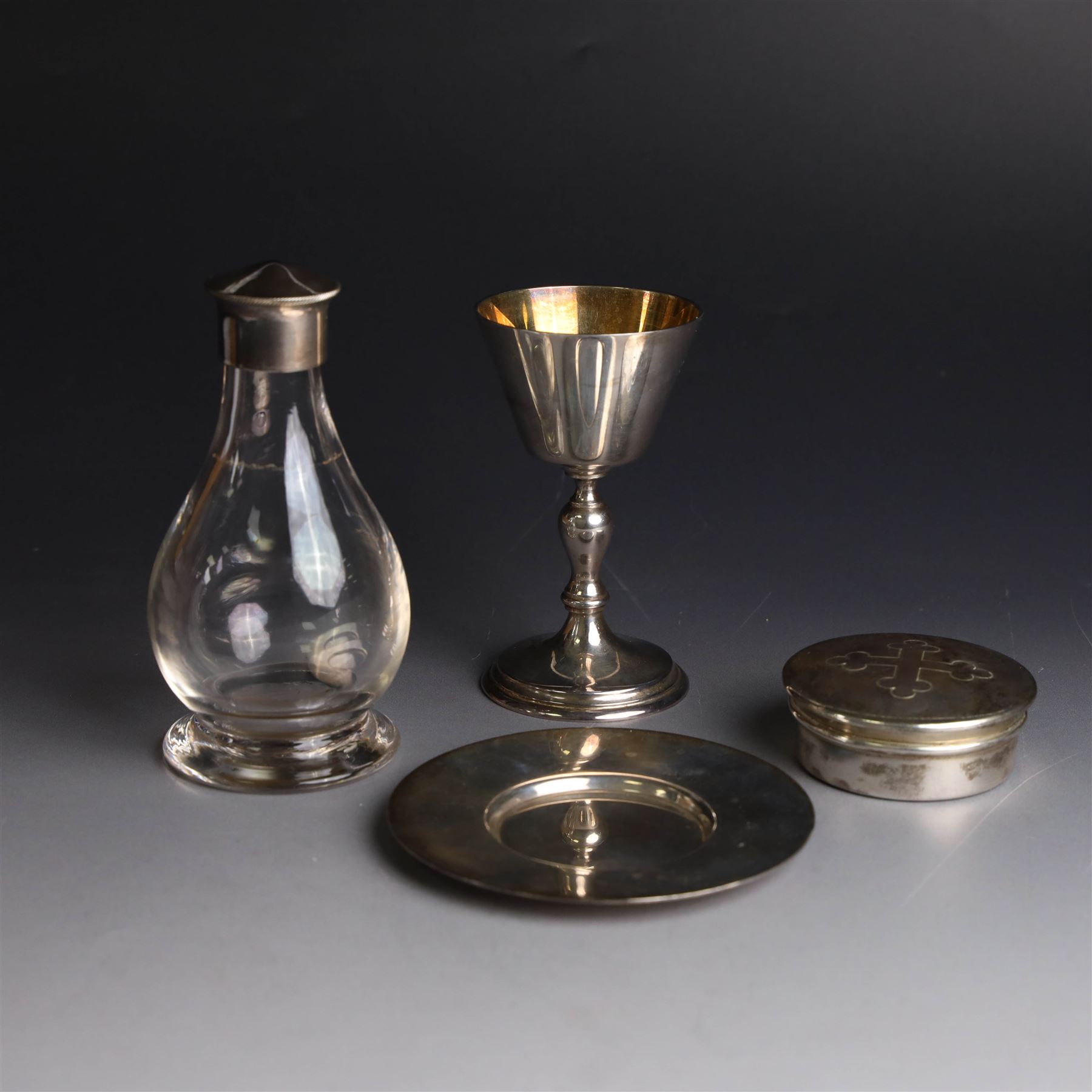 Mid 20th century silver travelling communion set, comprising goblet, paten and pyx, all hallmarked Hurst, Franklin & Co Ltd, London 1961 & 1962, with a glass bottle with unmarked cover, all within a tooled leather fitted case, goblet H9cm