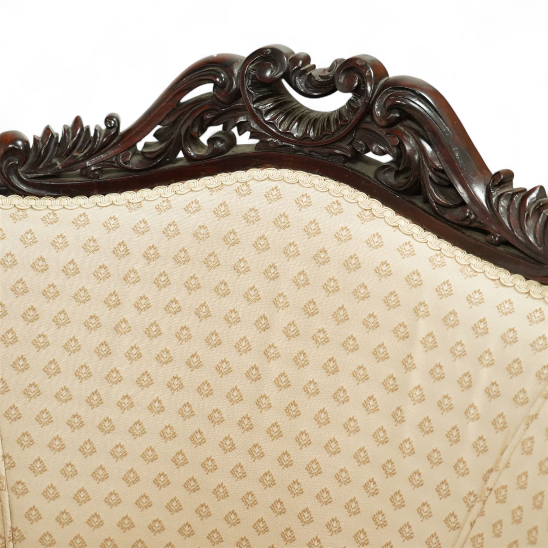 Victorian carved mahogany tub chair, upholstered in cream patterned fabric, with pierced foliate carved top rail, curved back and seat, serpentine seat rail, on cabriole front legs with brass castors