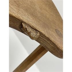 'Mouseman' oak three legged stool with dished kidney shaped seat, tapered octagonal supports, with carved mouse signature, by Robert Thompson of Kilburn
