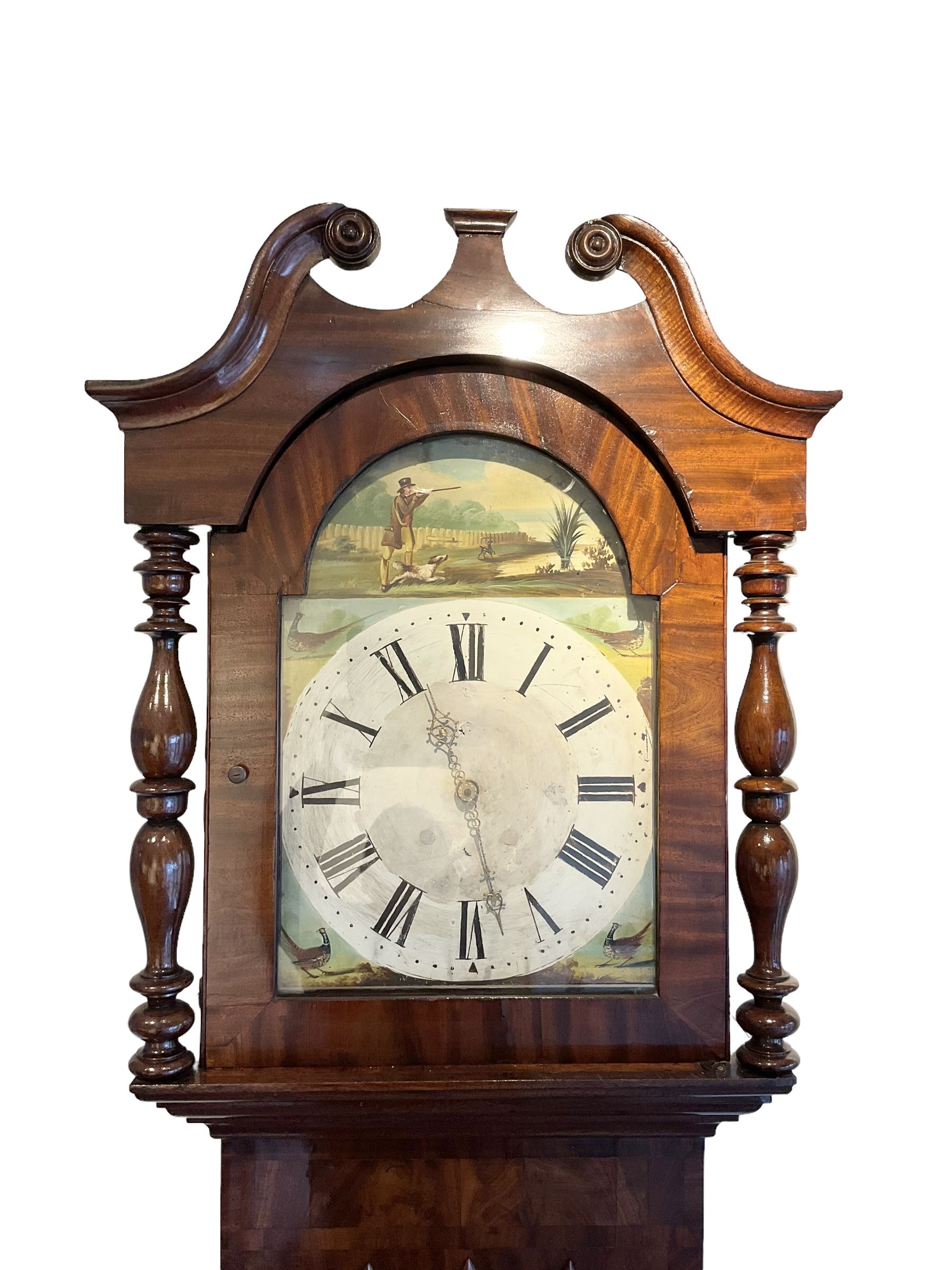 Late 19th century 30 hour Yorkshire mahogany longcase clock, with a swans necked pediment and break arch hood door flanked by two ring turned pilasters, trunk with a short door with a bone escutcheon on a wide plinth with a recessed panel, painted dial with a depiction of a sportsman to the arch and game birds to the spandrels, Roman numerals, minute markers and brass hands, chain driven countwheel striking movement. With weight and pendulum.