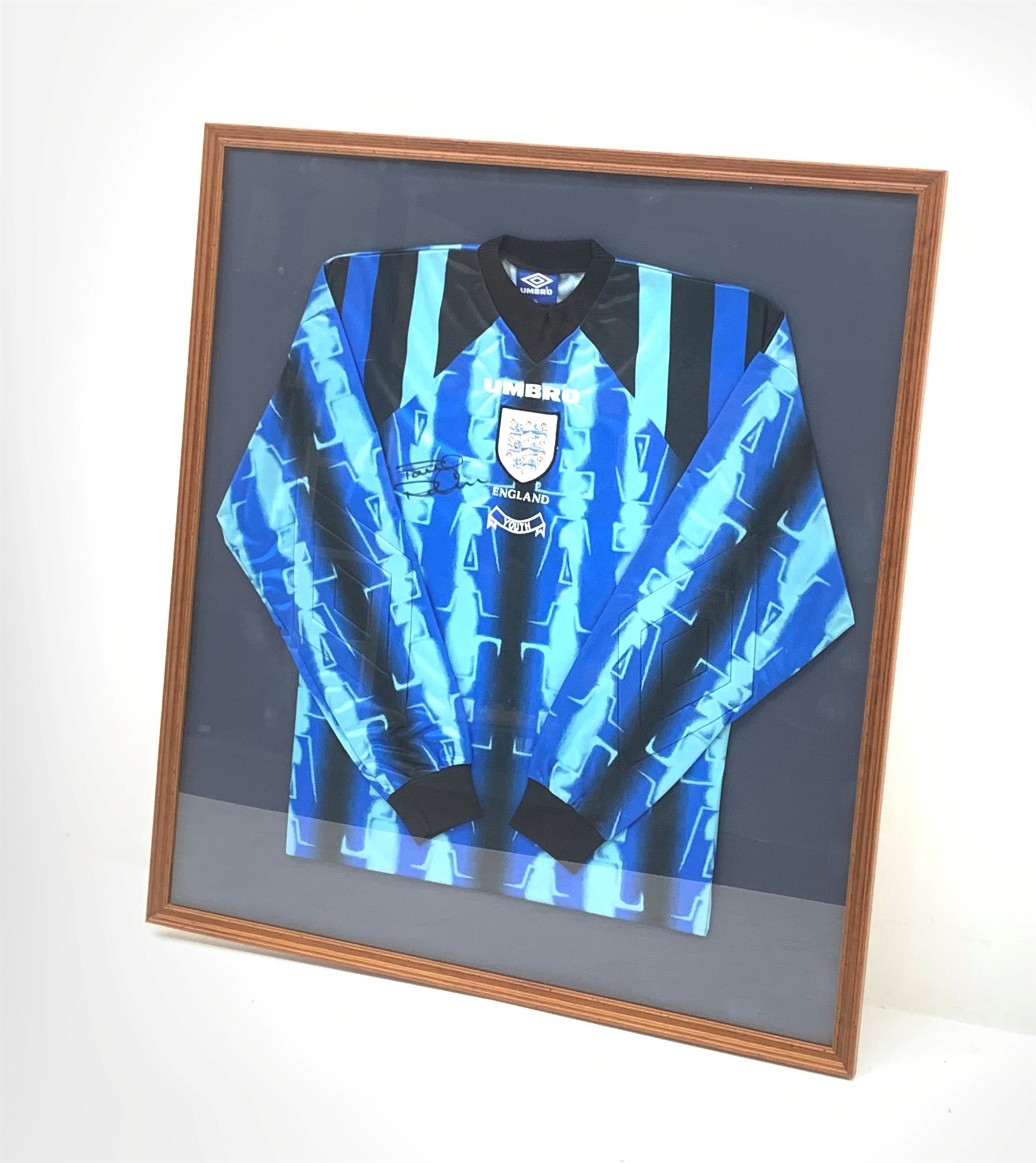 England Youth goalkeeper's shirt worn by Paul Robinson on his first international appearance for England and signed by him, mounted in a wall hanging display frame 89 x 80cm. Provenance: the vendor was a coach at Robinson's club Leeds United and was given the shirt by him.