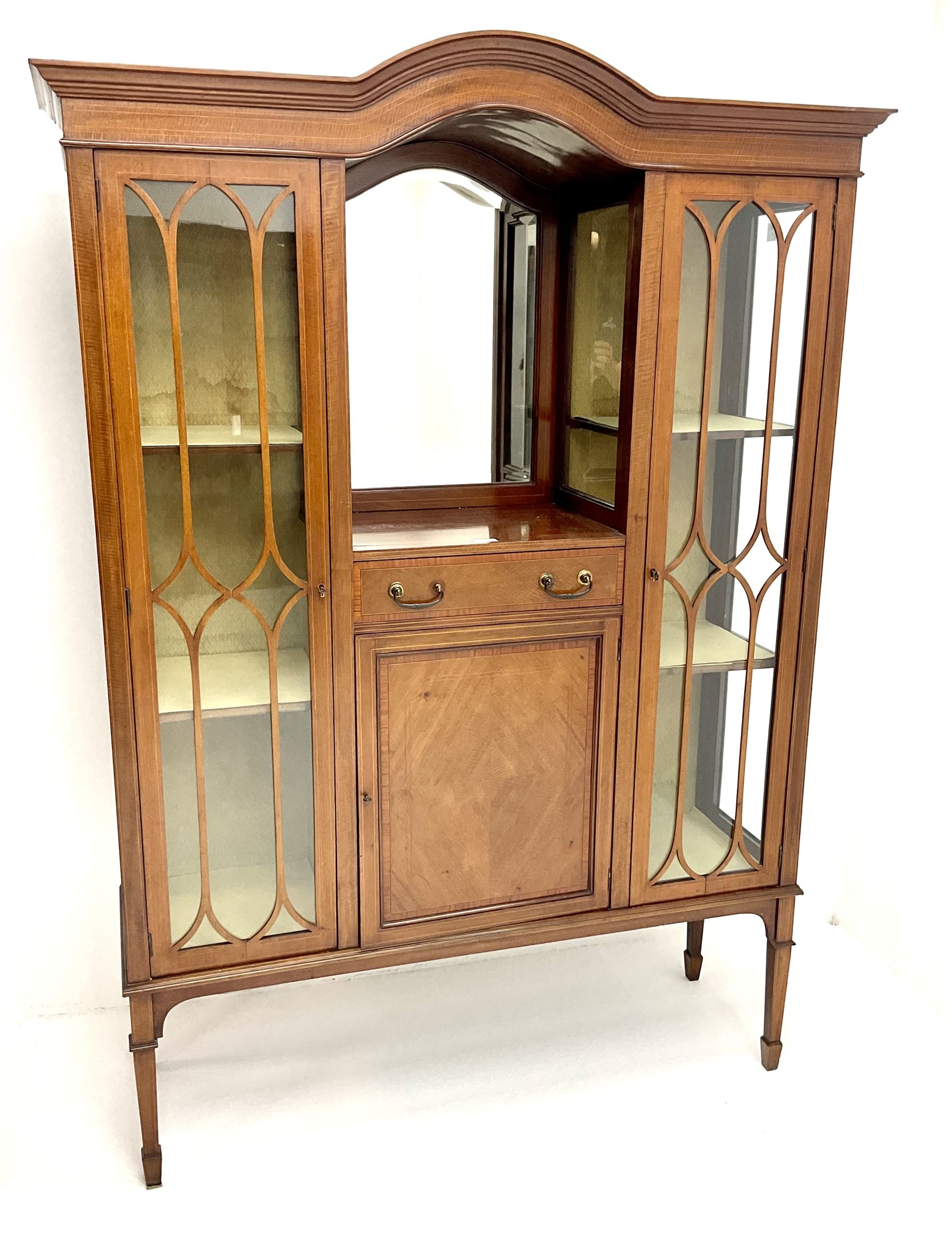Edwardian inlaid mahogany display cabinet with ‘Shepard, Bennington & Co. Doncaster’ makers plaque, central bevel edge mirror flanked by two glazed doors enclosing two lined shelves, single drawer above cupboard on square tapering supports with spade feet