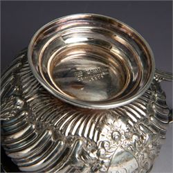 Victorian silver four piece tea service, comprising hot water pot, teapot, milk jug and sugar bowl, of circular part fluted bellied form, with embossed and engraved floral decoration, engraved with initials to body, the teapot and hot water pot with wooden handles and finials, hallmarked Z Barraclough & Sons, Sheffield 1898