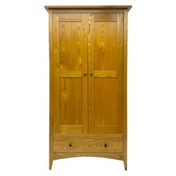 Contemporary light oak double wardrobe, projecting cornice over two panelled doors enclosing hanging rail and shelf, above full-width drawer, on shaped stile supports