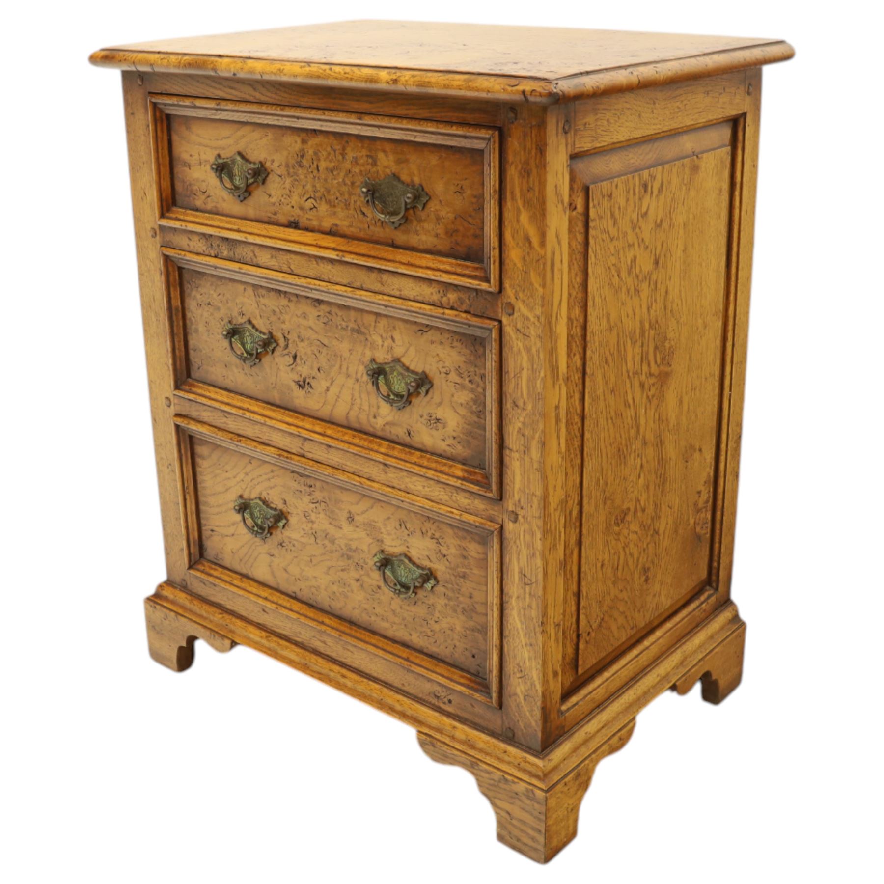 Small 20th century burr oak chest, the figured top over three graduated drawers with moulded fronts and pierced brass handles, on shaped feet