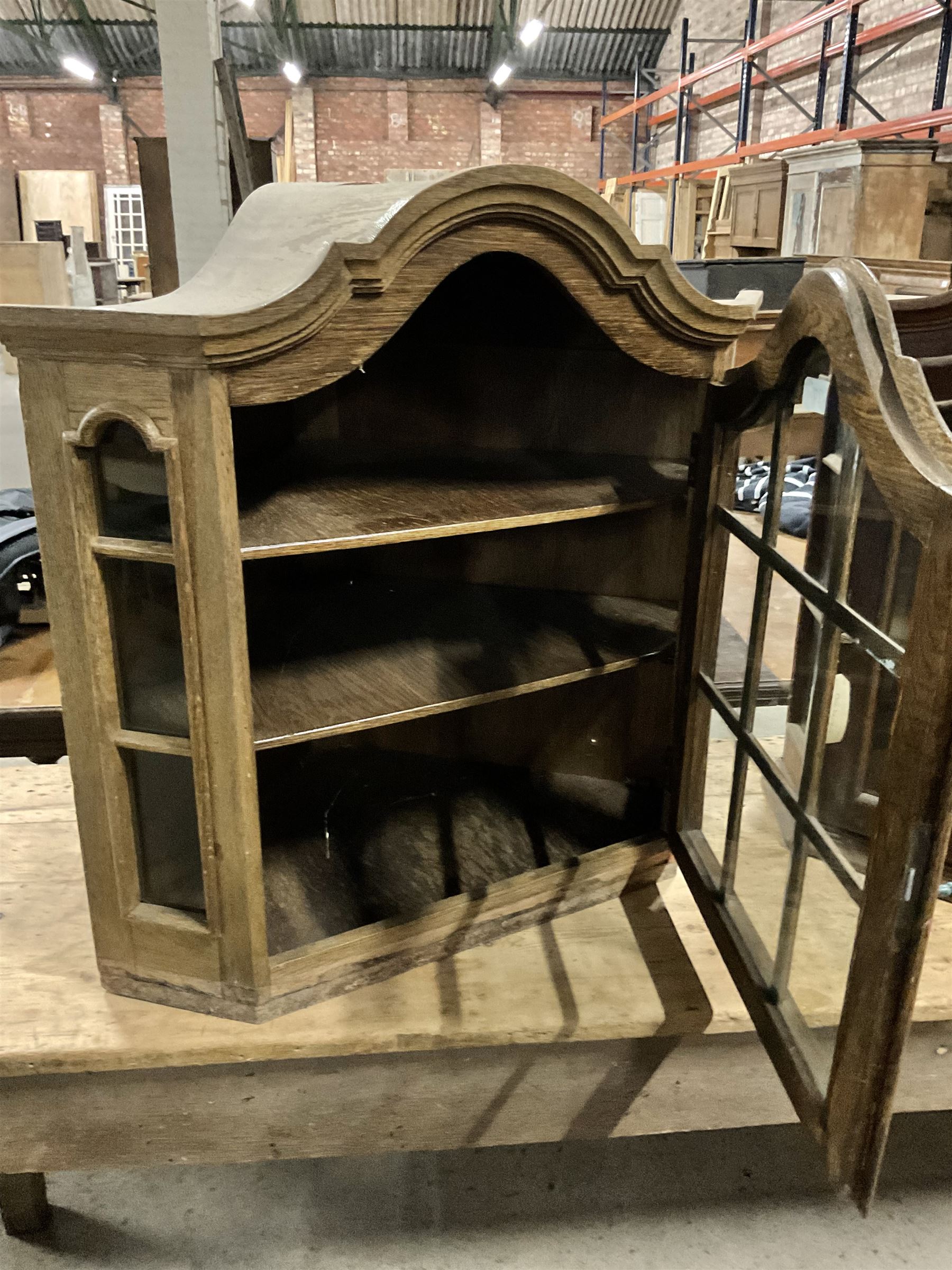 Dutch design oak wall hanging apothecary cabinet, of arched form with single astragal style glazed door enclosing single shelf (W69cm D18cm H69cm); together with another similar of corner form (W75cm D48cm H69cm) - THIS LOT IS TO BE COLLECTED BY APPOINTMENT FROM THE OLD BUFFER DEPOT, MELBOURNE PLACE, SOWERBY, THIRSK, YO7 1QY