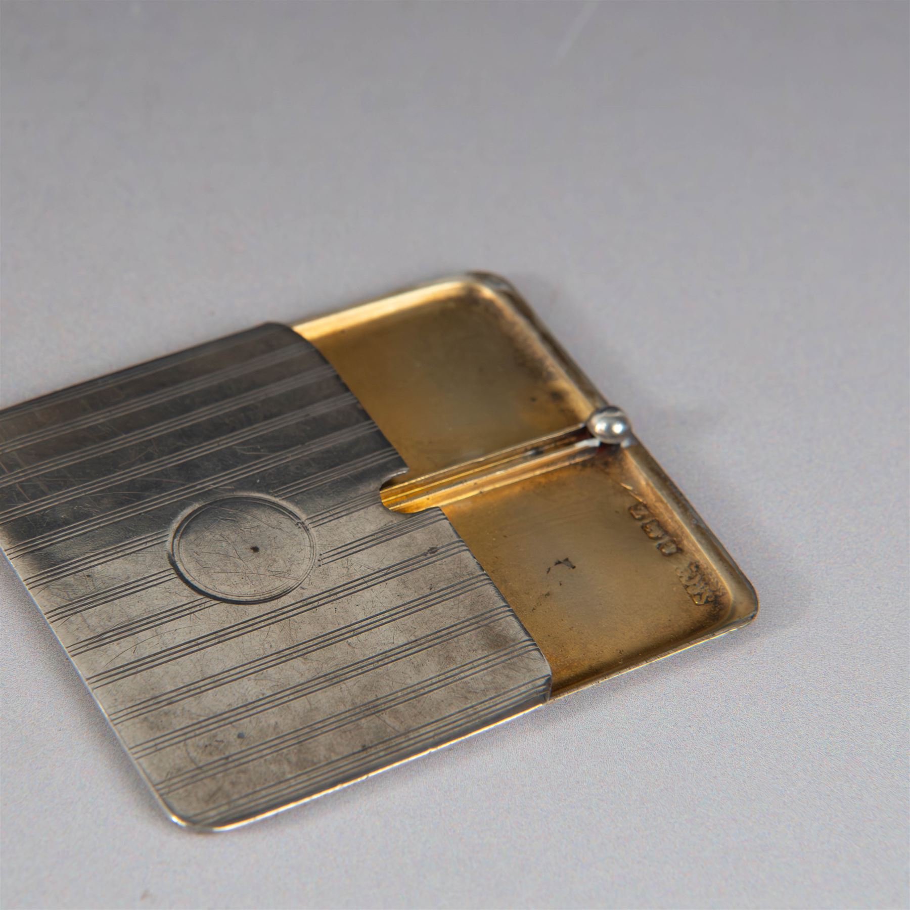 Two silver stamp cases, comprising Victorian silver mounted example with leather interior and engraved monogram to cover, hallmarked George Unite, Birmingham 1897, and a 1920s sliding example with engine turned decoration and vacant cartouche, hallmarked Sydney & Co, Birmingham 1924