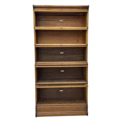 The Globe Wernicke Co. Ltd. - early 20th century oak five-tier stacking library bookcase, each section enclosed by hinged and sliding glazed door, on shaped plinth base 