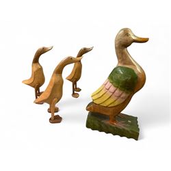 Three carved wooden DCUK ducks and a larger wooden duck figure, tallest H52cm