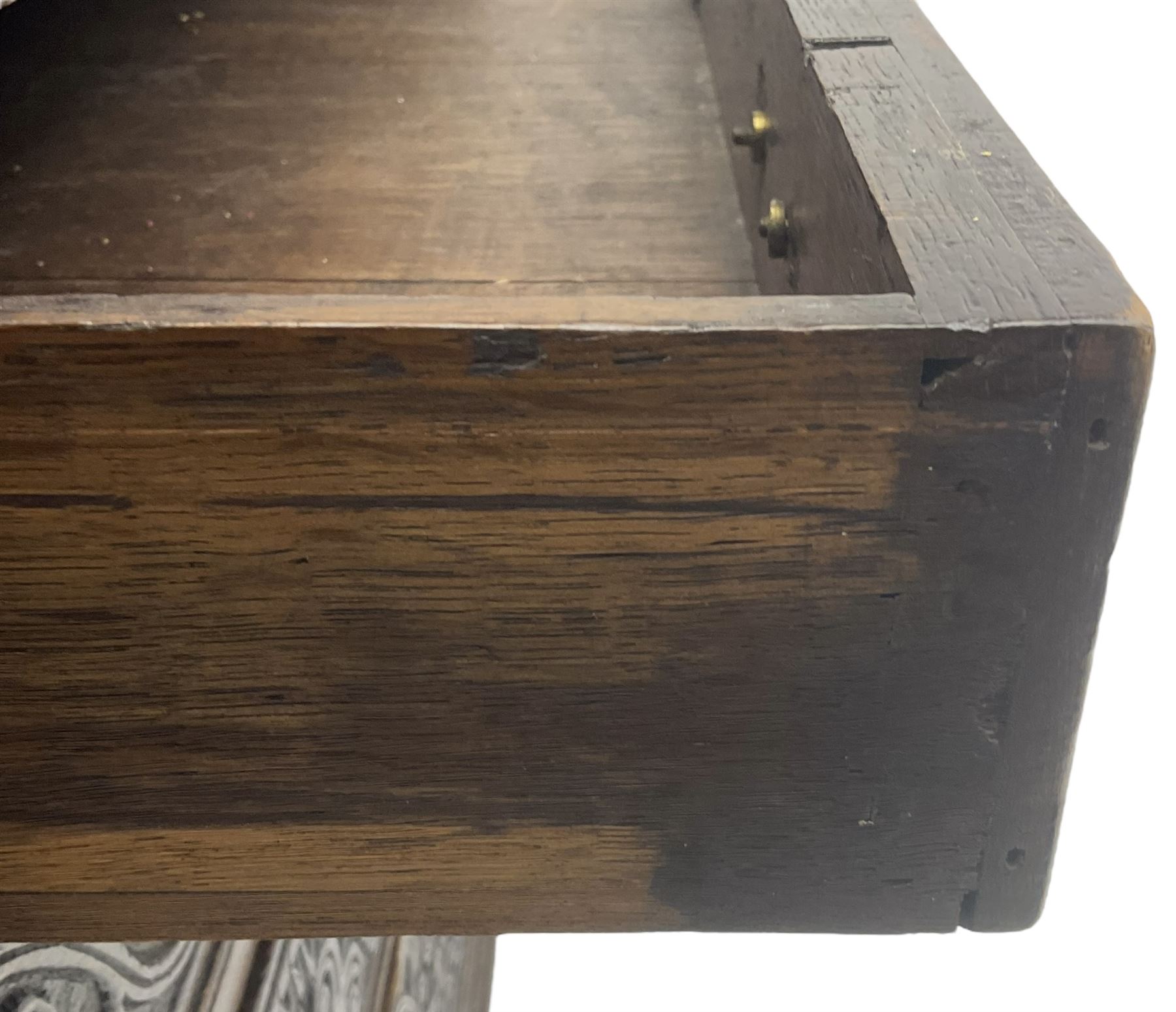 18th century heavily carved oak bureau, the fall front relief carved with three arches enclosing plants and flower head decoration, the interior fitted with pigeonholes, drawers and cupboard, four graduating cock-beaded drawers below, carved with lunettes and trailing foliage decoration, on bracket feet