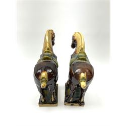A pair of glazed pottery Tang style horses, each with impressed marks beneath, each approximately H25.5cm. 