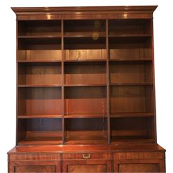 Early 20th century mahogany open bookcase, with reeded upright divisions and adjustable shelves, over a cupboard base fitted with three frieze drawers and three panelled doors, on plinth base