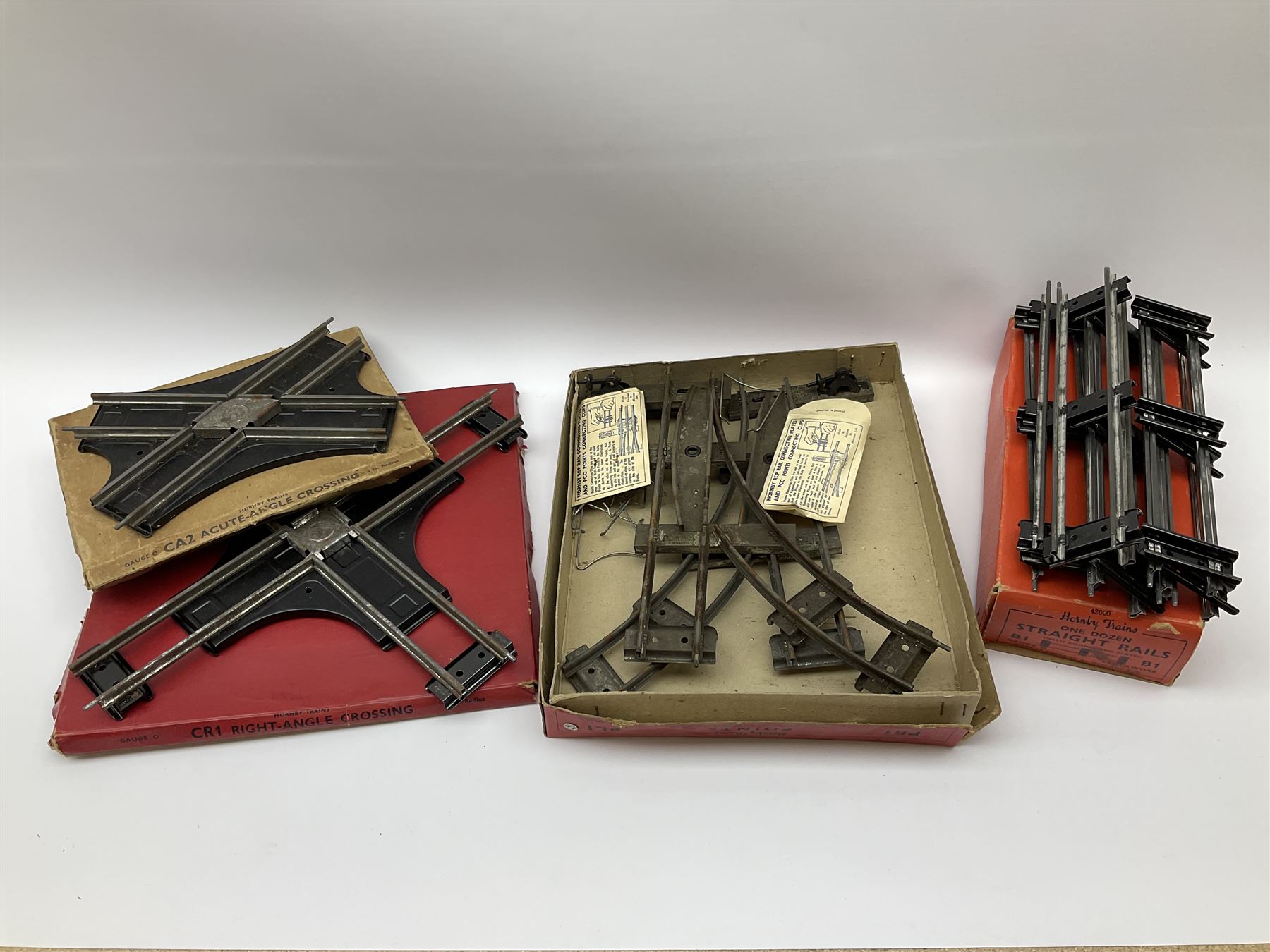 Hornby '0' gauge - layout accessories comprising PR1/PL1 Points, CR1 Right Angle Crossing and CA2 Acute Angle Crossing, all boxed; tin-plate signal box; tin-plate level crossing; textured wooden tunnel, possibly pre-WW2; and quantity of track, some boxed; together with '00' gauge tin-plate station