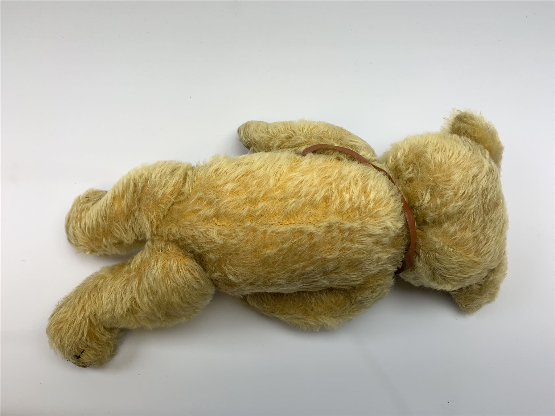 Merrythought Hygienic Toys large 'Magnet' teddy bear c1930s with plush body, swivel jointed head with glass eyes and vertically stitched nose and mouth and jointed limbs,  celluloid wishbone button to right ear and stitched label under right pad H22