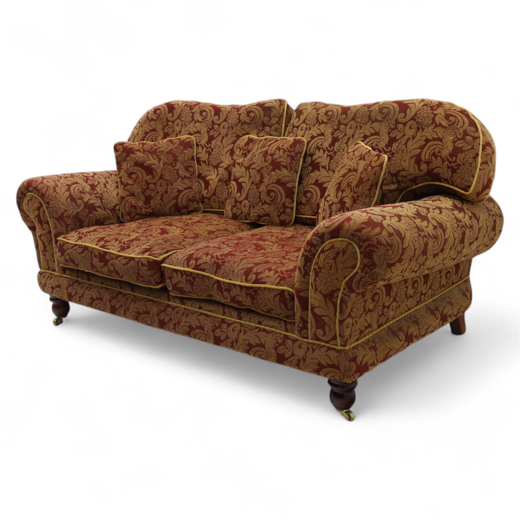 Duresta - two seat settee, upholstered in red and gold damask fabric with piped edges, scroll arms and loose feather-filled cushions, raised on turned wooden feet with brass castors