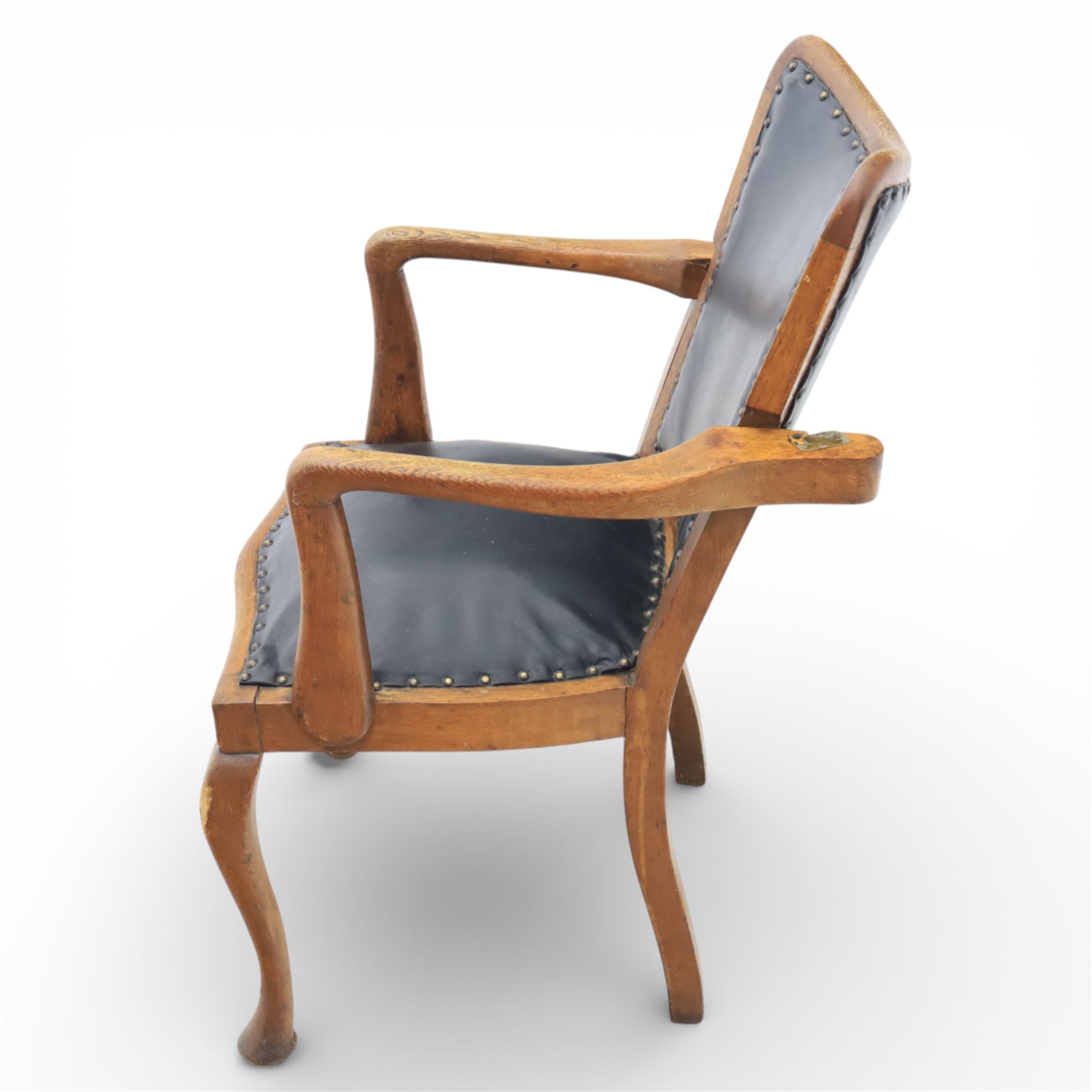 20th century oak recliner armchair, the curved back upholstered in leather with brass stud edging, hinged reclining back operated by side ratchet fittings, leather upholstered seat, shaped open arms, raised on cabriole legs