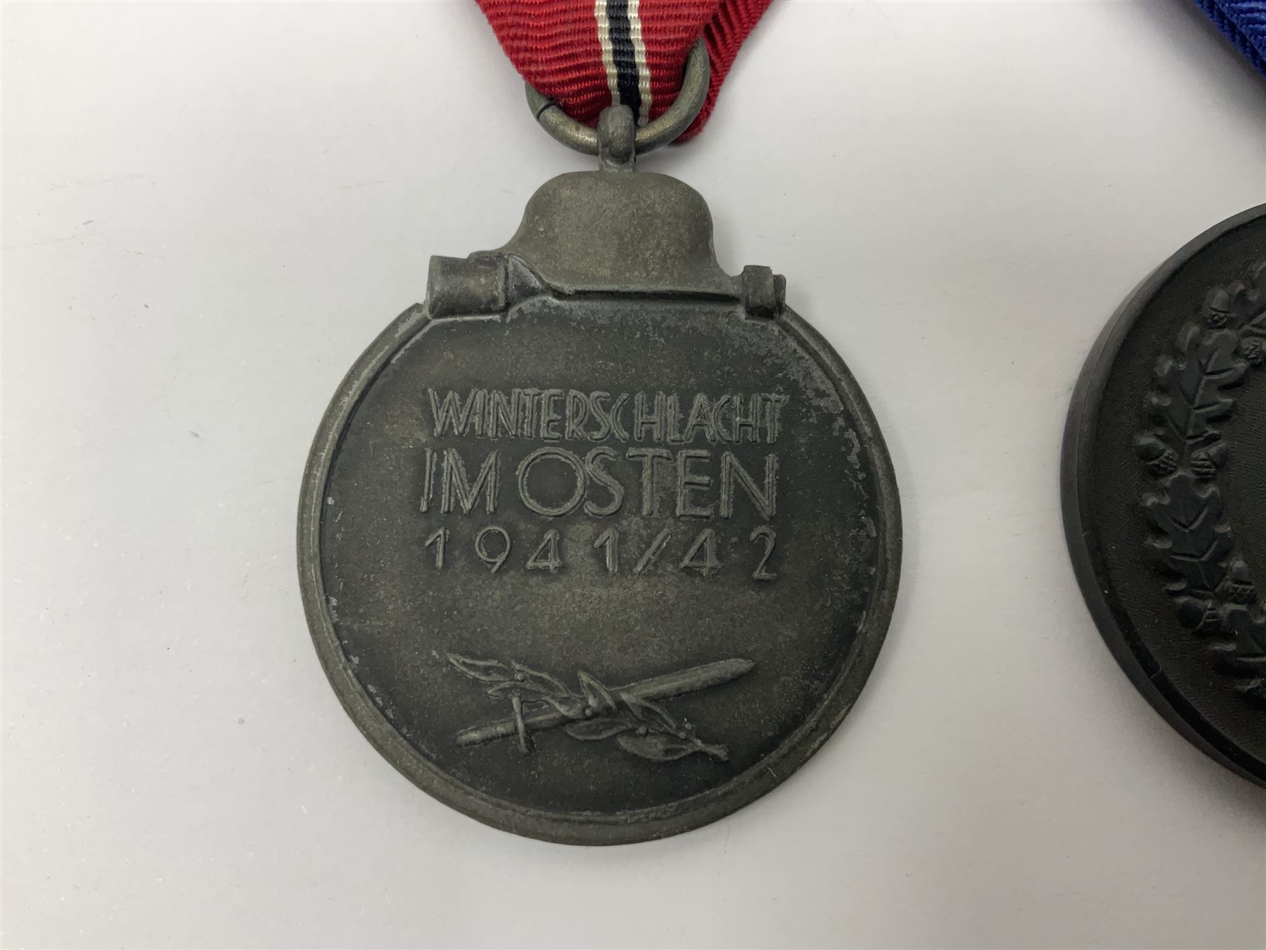WWII German 'SS' Long Service Medal for four years; Ostfront Medal for the Winter Campaign in Russia of 1941-1942 'Die Medaille Winterschlacht Im Osten'; and War Merit Cross 2nd Class with swords; all with ribbons (3)