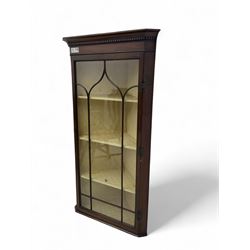 Early 20th century Georgian design mahogany wall-mounted corner display cabinet, projecting cornice with dentil frieze over astragal glazed door enclosing three fabric-lined shelves