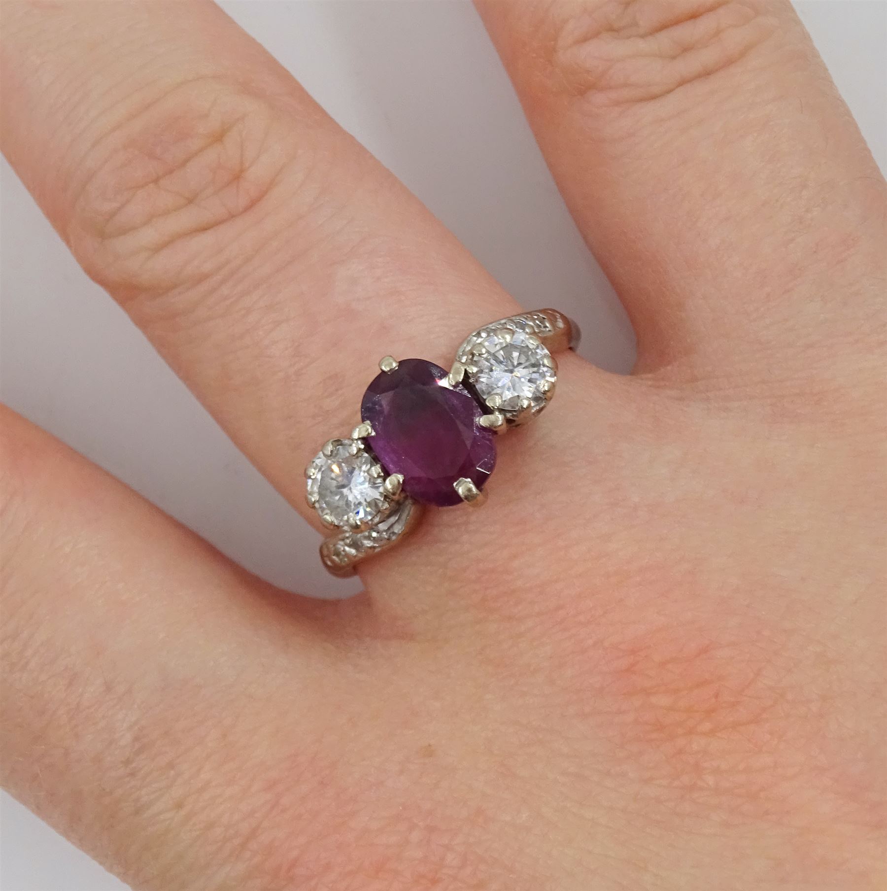 18ct white gold three stone oval ruby and round brilliant cut diamond ring, with diamond set shoulders, stamped, ruby approx 1.15 carat, total diamond weight approx 0.55 carat, in silver top ring box by The Victorian Ring Box Co, Edinburgh 1993 