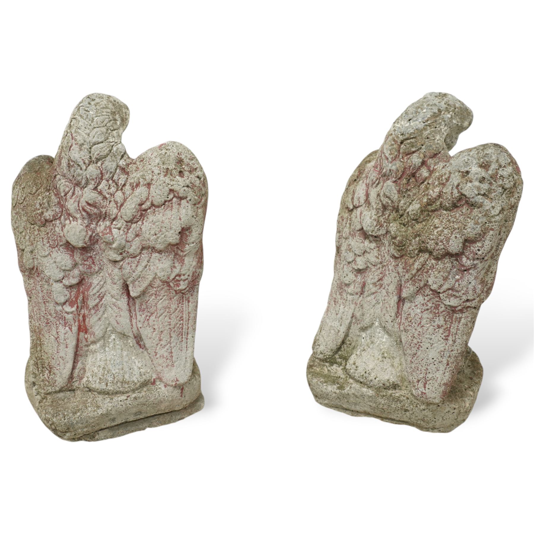 Pair of early 20th century painted stoneware eagle figures, modelled with wings partially spread and talons gripping prey, on a stone plinth
