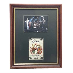 Queen - A Night At The Opera; fabric Stage Pass signed by all four members Freddie Mercury, Brian May, Roger Taylor and John Deacon 14 x 9.5cm; mounted in a modern frame with print of the band during a performance