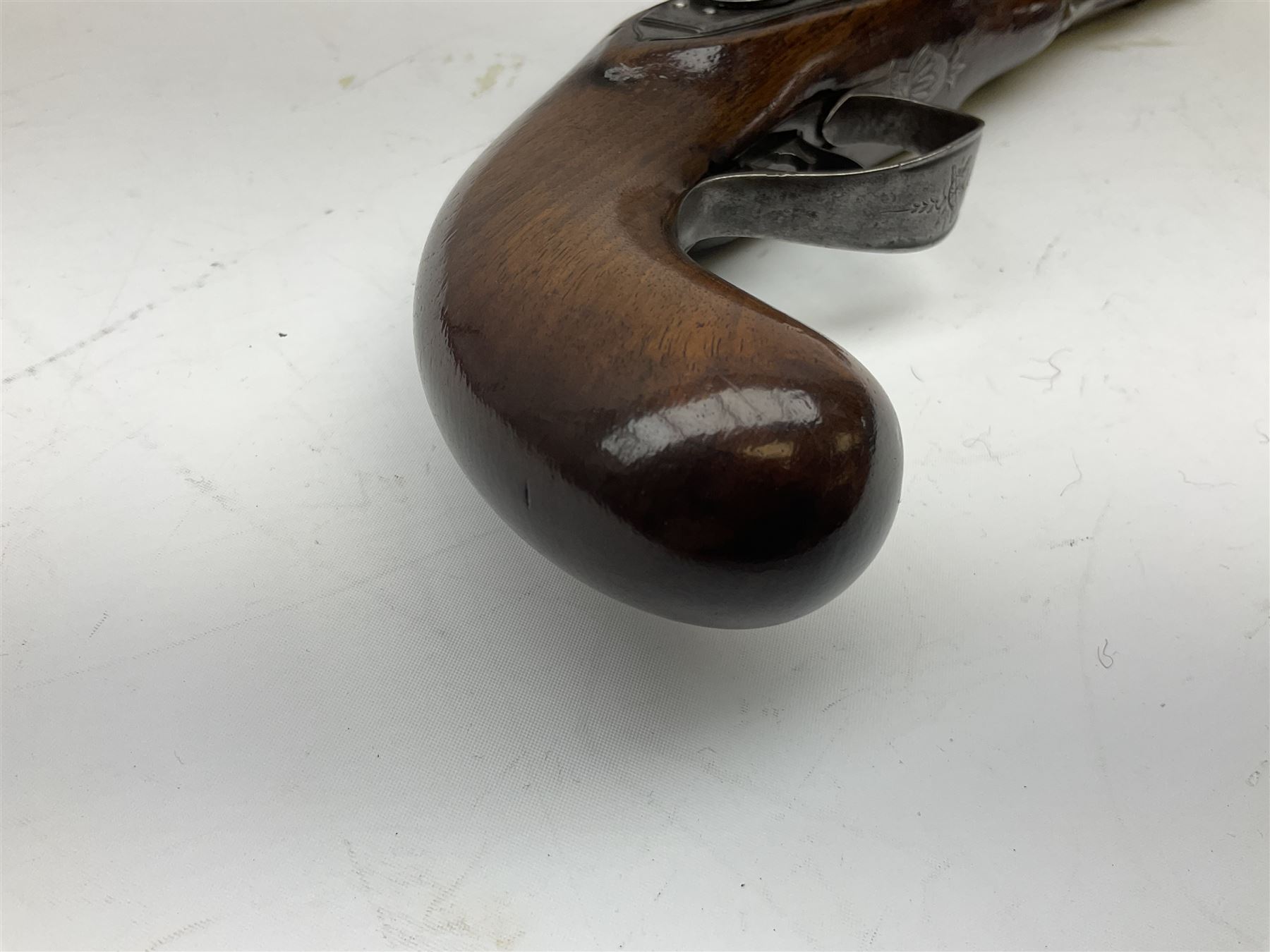 Early 19th century flintlock 16-bore overcoat/duelling pistol by William Bond Lombard Street London, the 23cm octagonal brown stub twist damascus barrel with small foresight, two barrel pins and ram rod under, inscribed Lombard Street London to the top and W. Bond to the action, full walnut stock with lightly engraved steel furniture, pineapple finial and escutcheon, half cock facility L39cm; loose mounted on later mahogany display stand with trade label