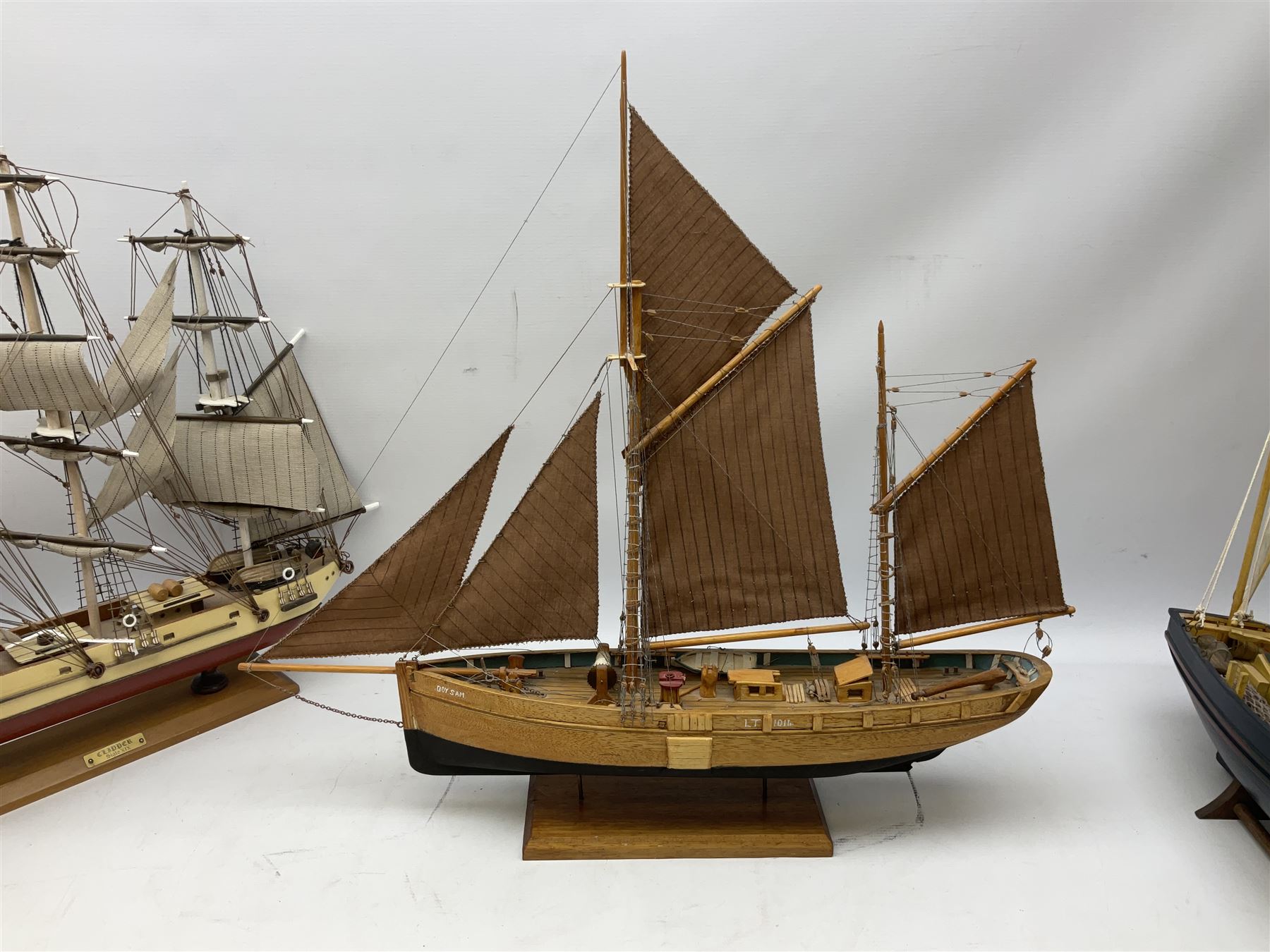 Eight model ships or boats including fishing boat with fish, nets and buoyancy aid, two mast sailing ship complete with cannons, two mast yacht with detailed rigging and life boat etc, the largest L72cm, H60cm